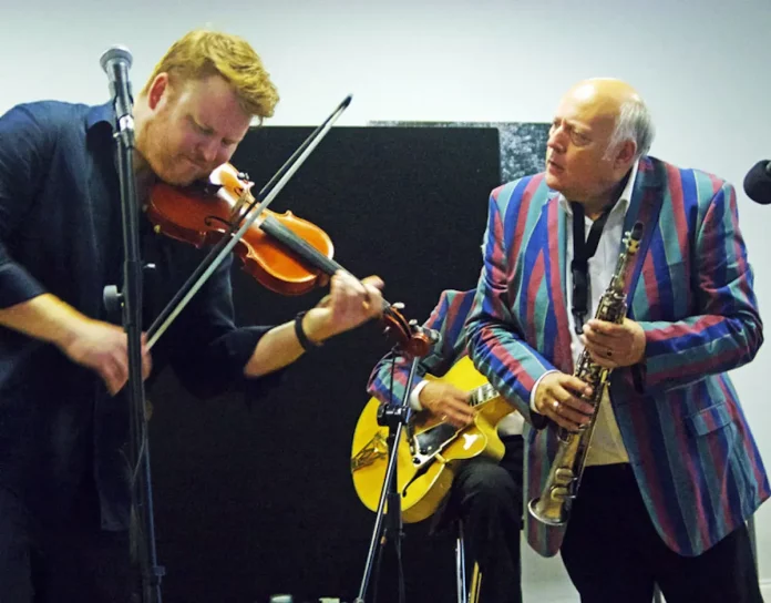 Pete Allen (right) intrigued by violinist Ben Holder at Deanwood Park golf club, Newbury, in 2019. Photo Brian O'Connor
